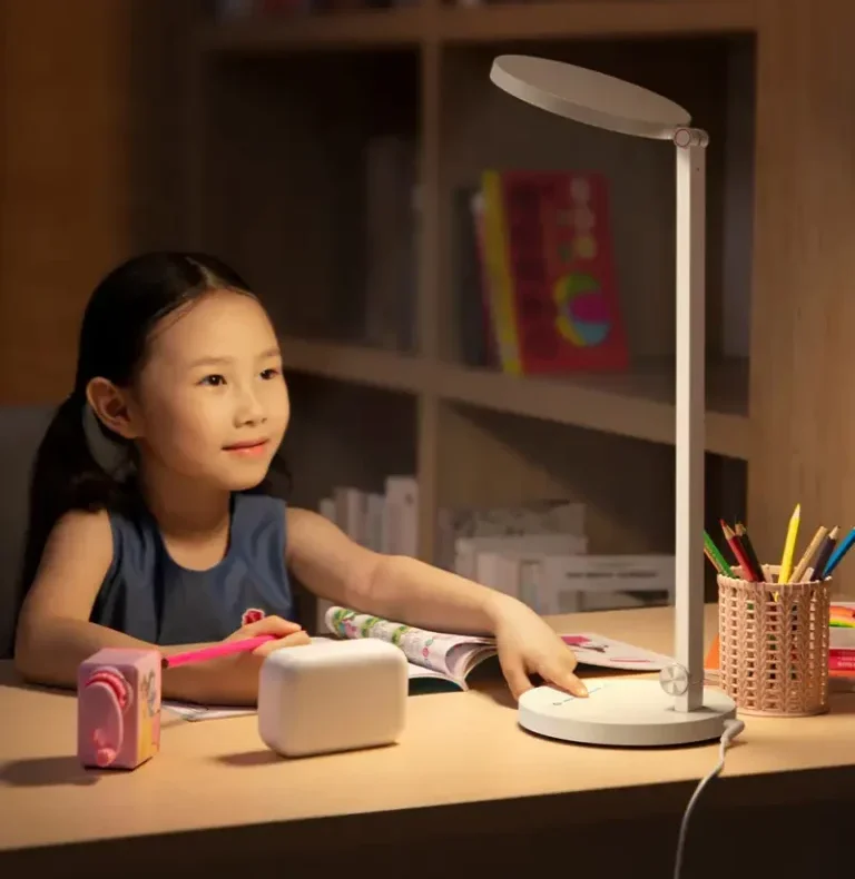 Baseus DGHY-02 Desk Lamp Base Control Lifestyle Child touching the base control of a white Baseus DGHY-02 desk lamp beside an open book