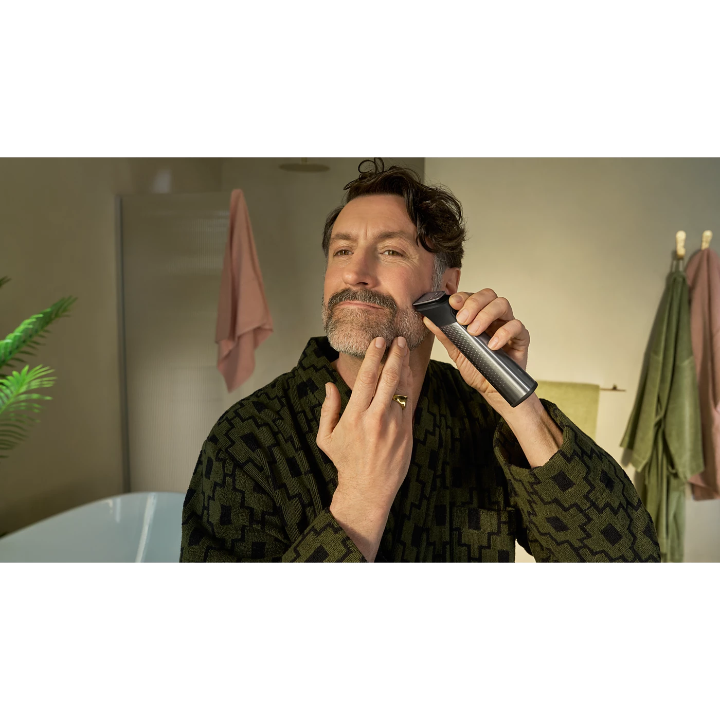 Philips Beard Trimmer in Use Man using a Philips beard trimmer to shape the beard along his cheek
