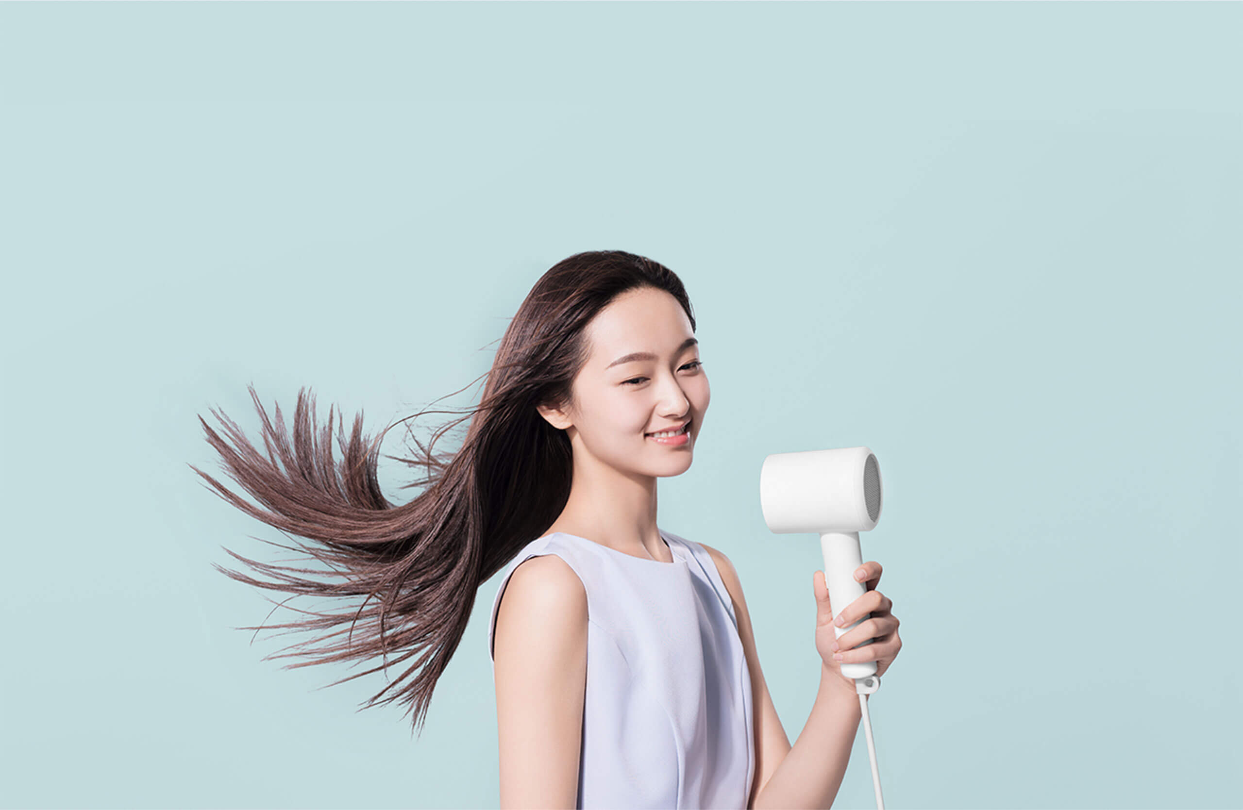 Xiaomi Mijia H300 Hair Dryer in Use Woman drying her long hair with a white Xiaomi Mijia H300 hair dryer