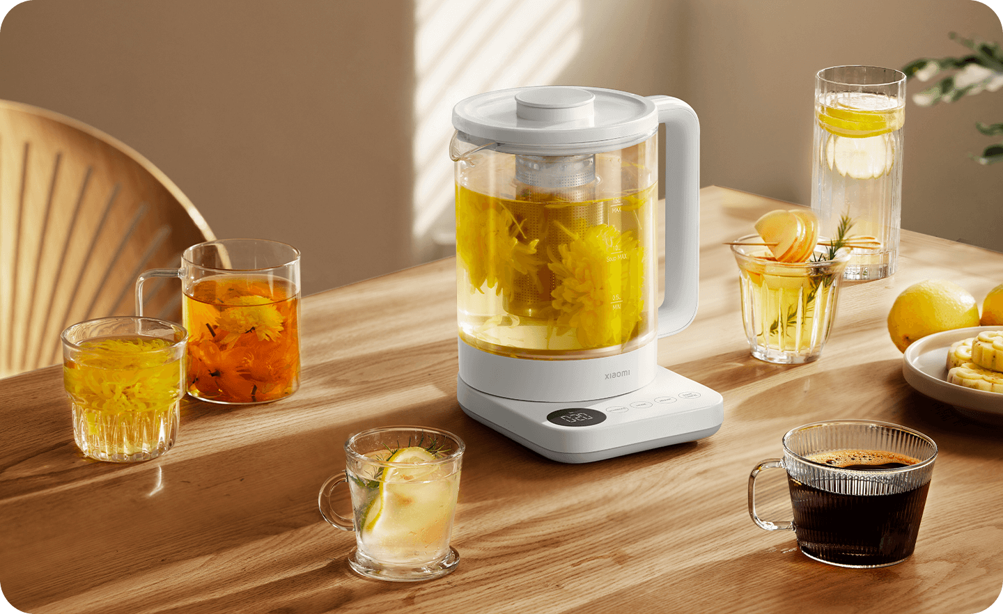 Xiaomi Mijia Health Kettle N1 – Tea Table Display Xiaomi Mijia Health Kettle N1 brewing flower tea on a wooden table surrounded by glass cups and lemon drinks