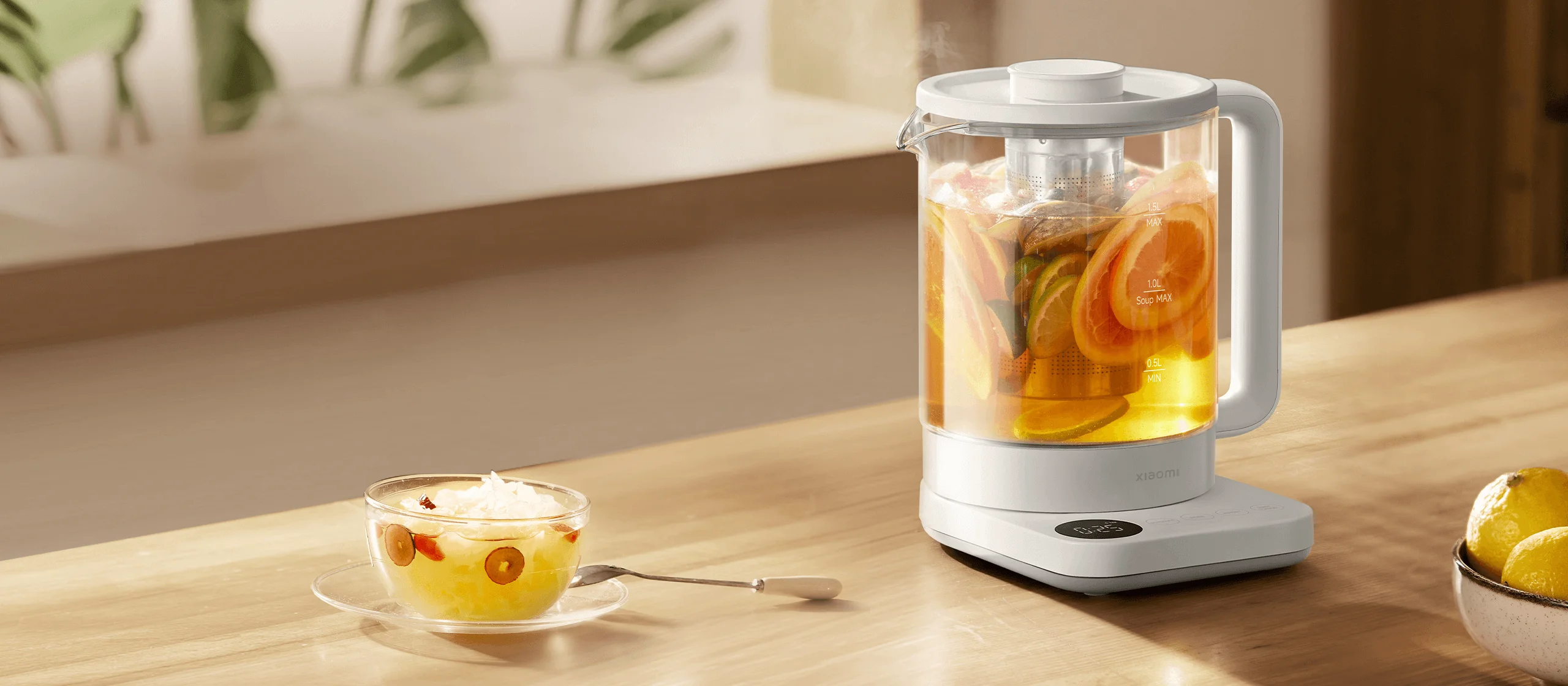 Xiaomi Mijia Health Kettle N1 – Citrus Tea Display Xiaomi Mijia Health Kettle N1 with citrus slices and golden tea beside a glass teacup on a wooden table