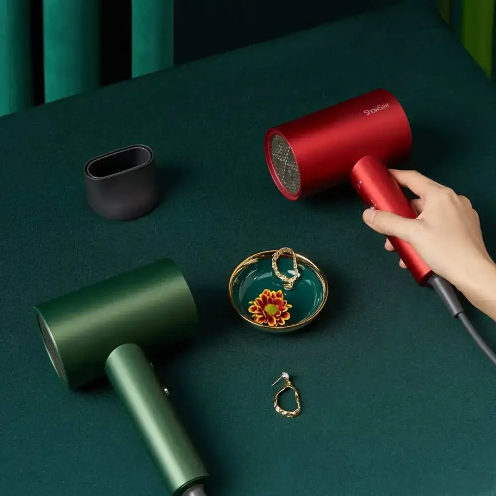 SHOWSEE A5-R and A5-G Hair Dryer Color Variants Red and green SHOWSEE A5 hair dryers on a dark green surface with a detached nozzle