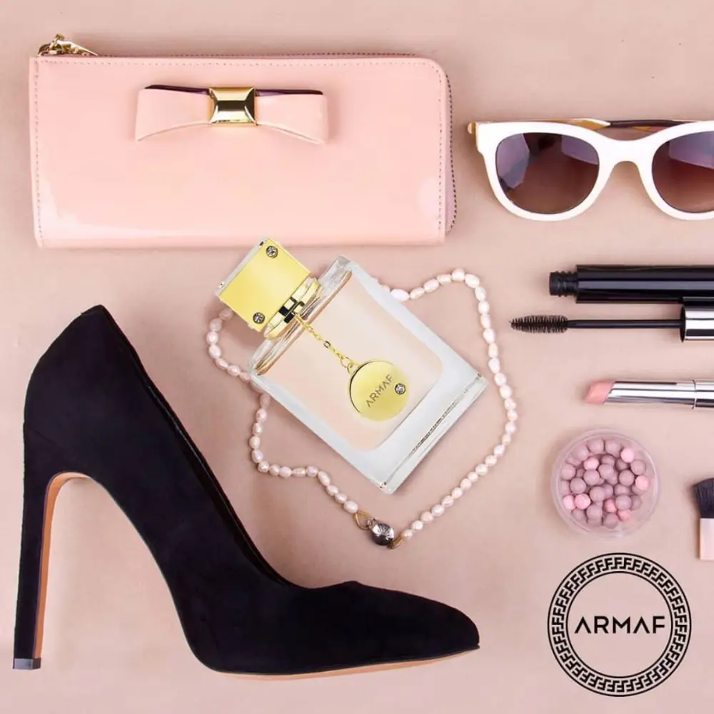 Armaf Club de Nuit Woman EDP Lifestyle Image Armaf Club de Nuit Woman perfume beside a pink wallet, sunglasses, pearl necklace and black high heel
