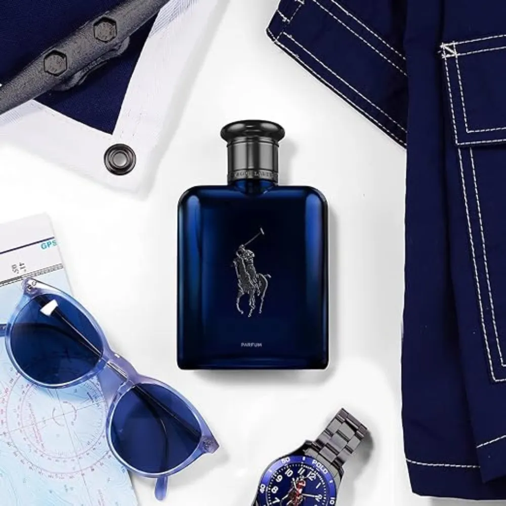 Ralph Lauren Polo Blue Parfum Lifestyle Image Ralph Lauren Polo Blue Parfum bottle beside blue sunglasses, a wristwatch and navy clothing